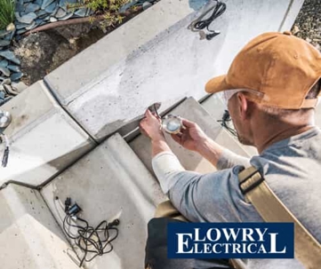 An electrician installing a light fixture.