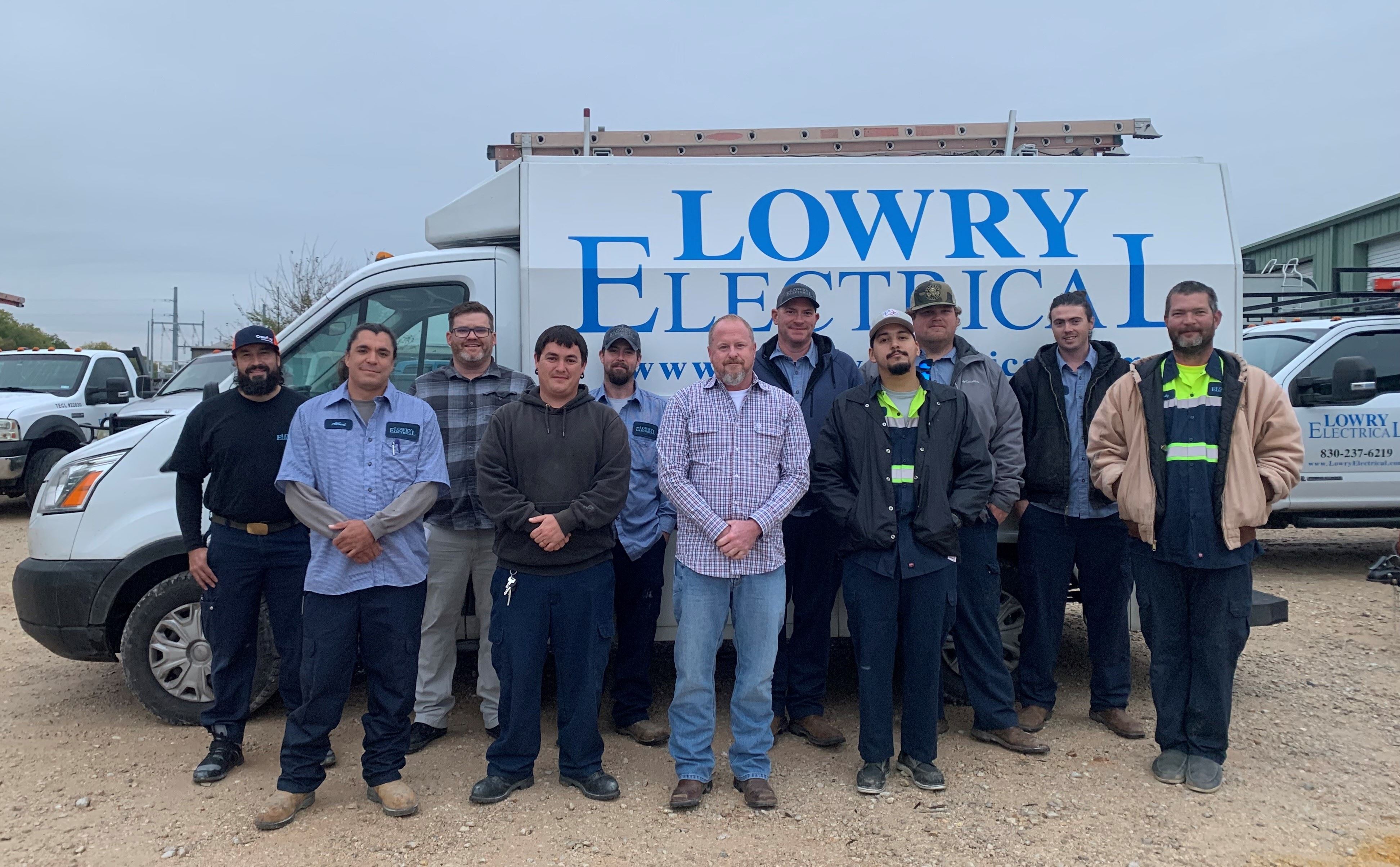 lowry electrical team in front of our building with signage on top